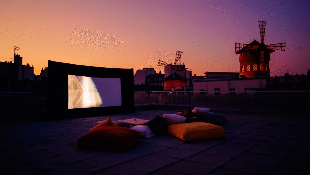 Moulin Rouge illuminé de nuit pour une séance de cinéma en plein air sur son rooftop