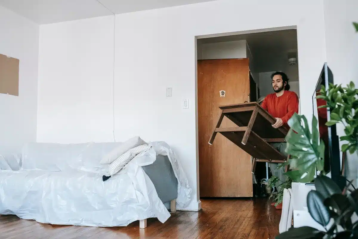 Déménagement en escalier étroit d'un immeuble urbain avec meuble volumineux emballé