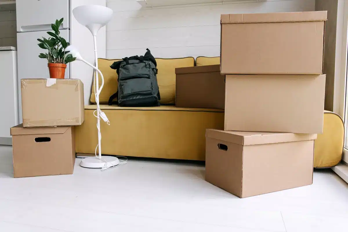 Cartons de déménagement empilés dans une pièce vide avec un devis sur une table