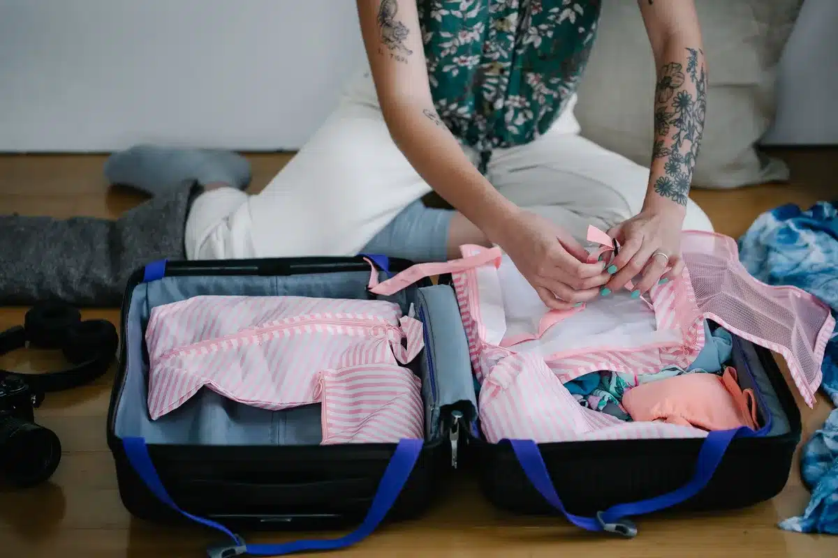 Valise ouverte avec vêtements pliés, chaussures confortables et accessoires de voyage essentiels