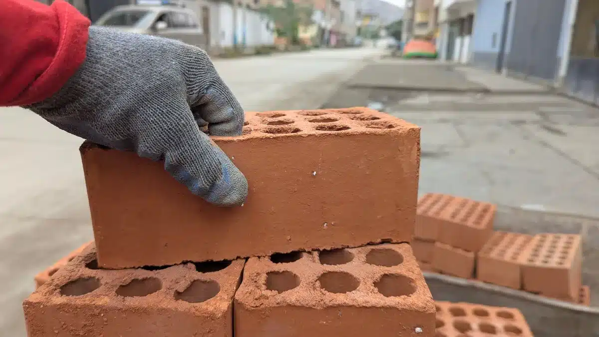 Maçon posant des briques et du mortier sur un chantier de construction
