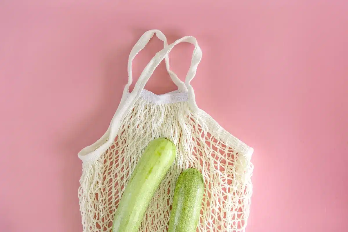 Mains pressant des courgettes râpées dans un torchon au-dessus d'un saladier