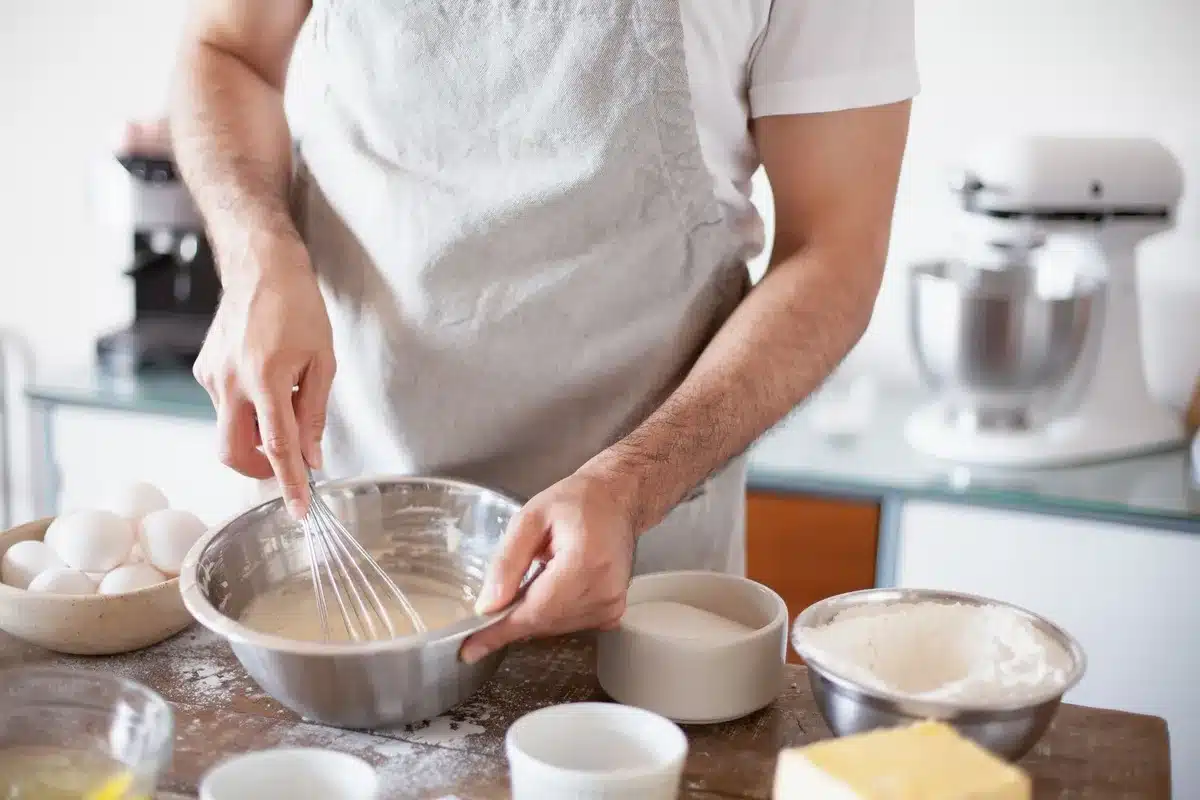 Préparation du biscuit roulé : mélange de jaunes d'œuf et sucre fouettés dans un bol