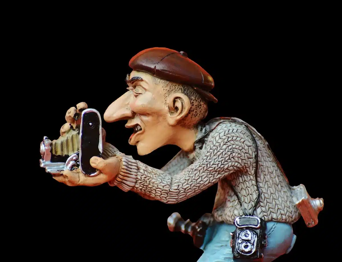 Photographe discret prenant une photo depuis un coin d'une salle de cinéma