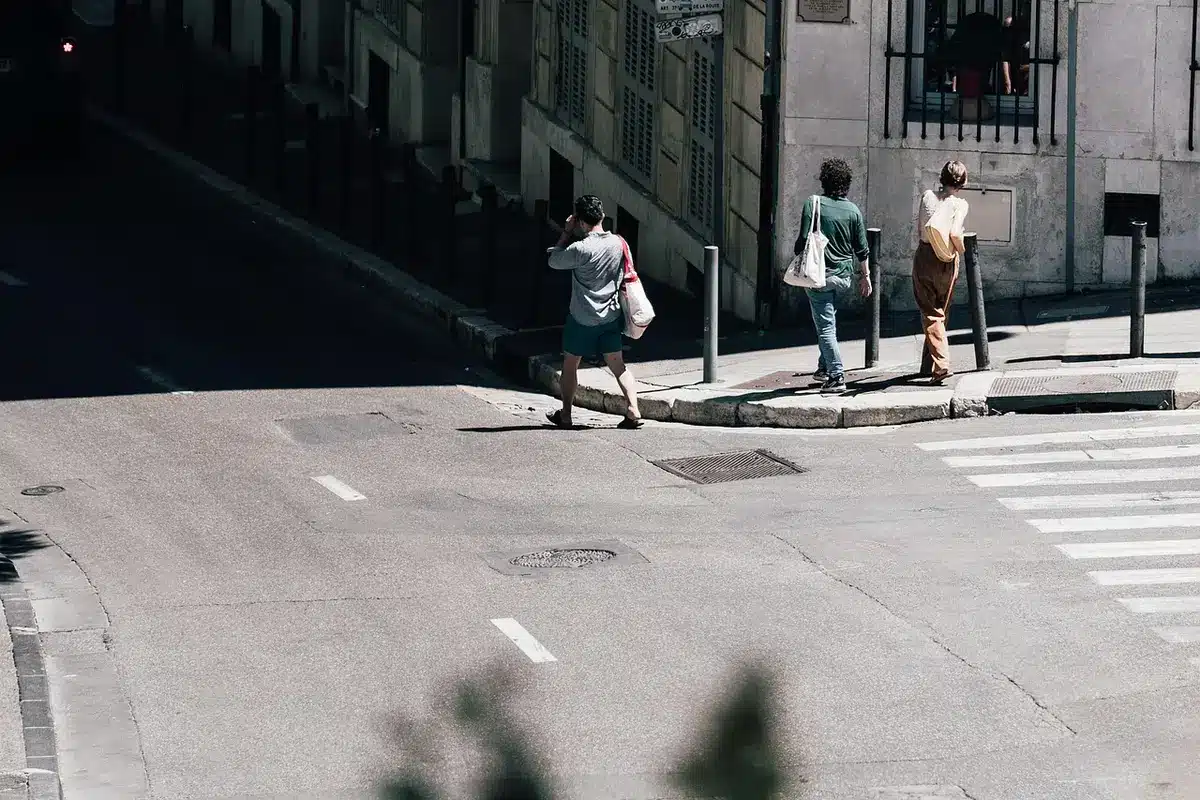 Piéton marchant sur un trottoir urbain avec attention à son environnement
