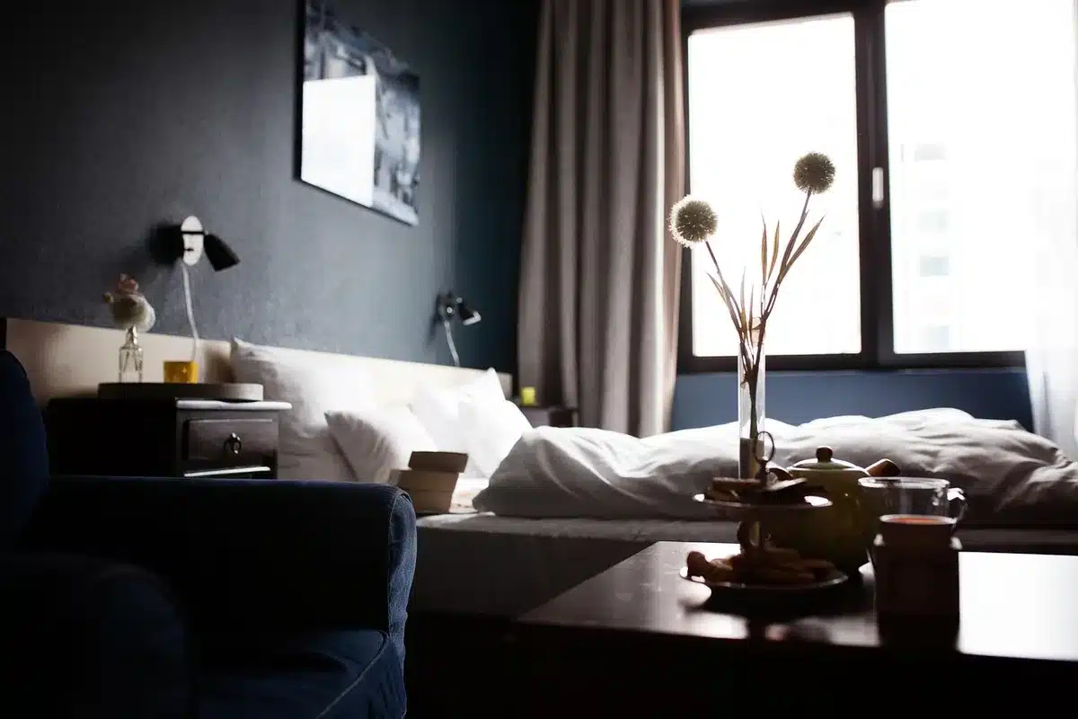 Chambre d'hôtel en journée avec poussette et affaires de bébé rangées