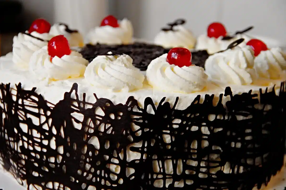 Montage d'un gâteau chocolat-céréises dans une cuisine lumineuse avec cadre à mousse