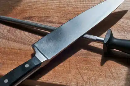 Évier de cuisine en plein jour, siphon ouvert et outils posés sur le plan de travail