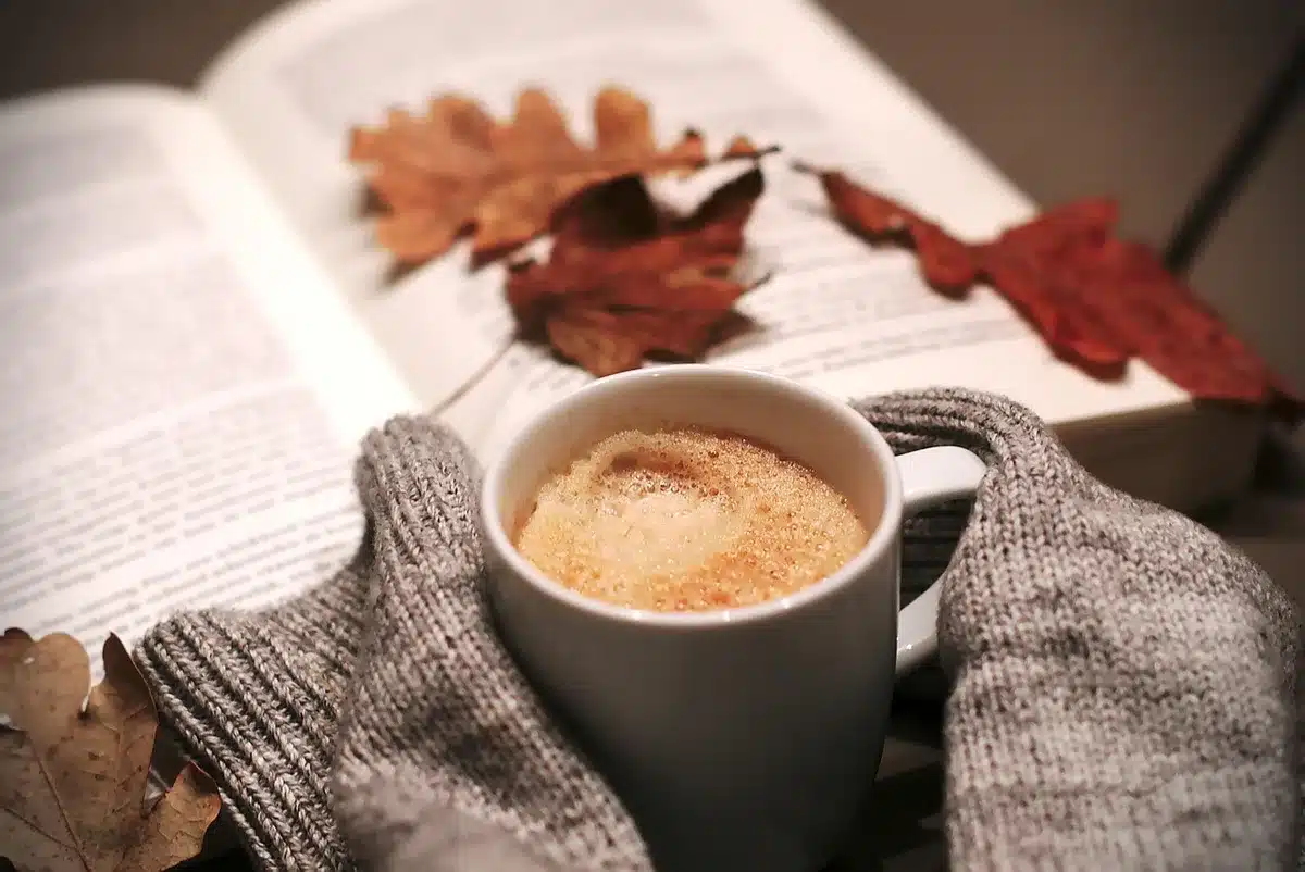 Personne détendue assise dans un fauteuil avec une tasse et une petite liste d'intentions