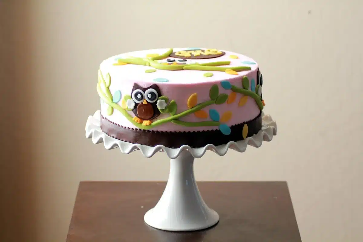 Main anonyme modelant de la pâte à sucre colorée sur une table claire