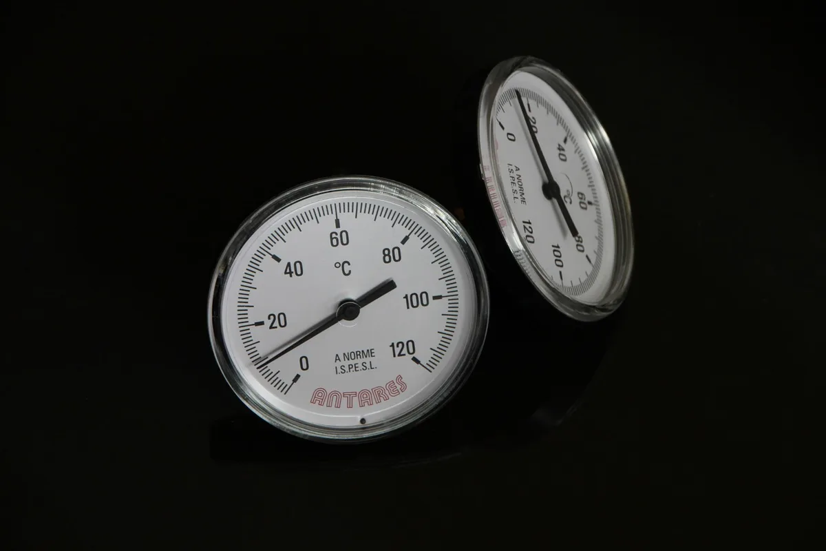 Coffret de commande et sonde de température posés près d'une piscine