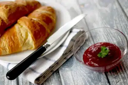 Table de petit-déjeuner près d'une fenêtre avec carnet et tasse de café, plein jour
