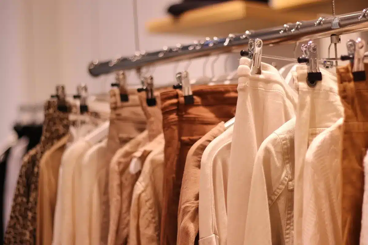 Capsule wardrobe organisée avec vêtements neutres pliés et suspendus