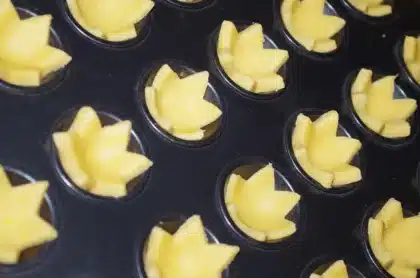Plan rapproché d'un plan de travail en cuisine avec pâte étalée et tartelette aux mirabelles à la lumière du jour